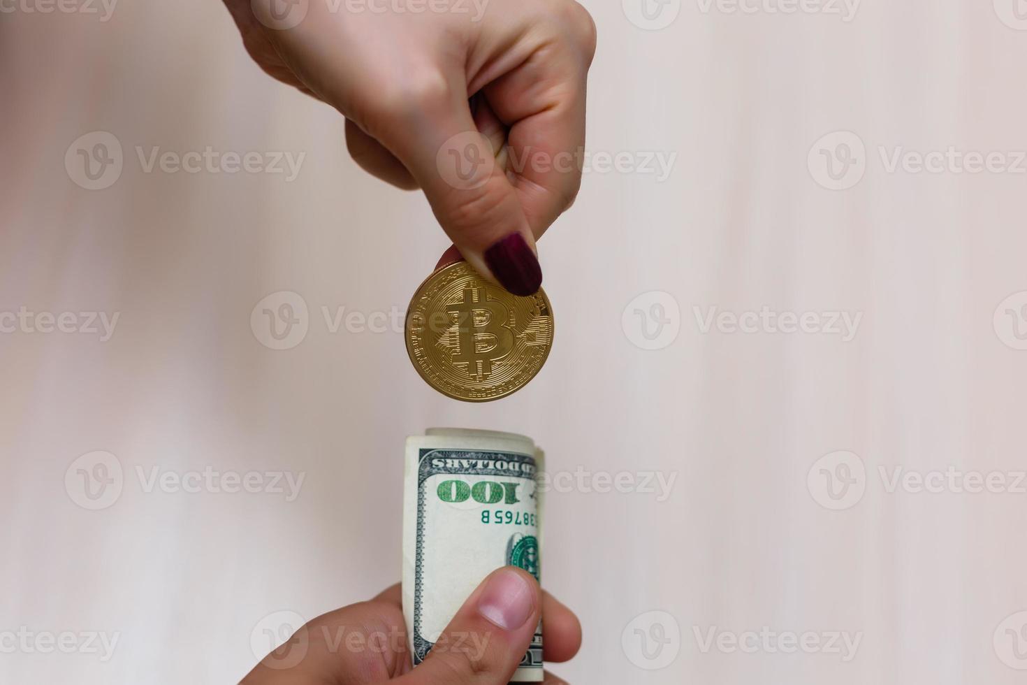 Golden bitcoins on us dollars in the hands electronic money exchange concept photo