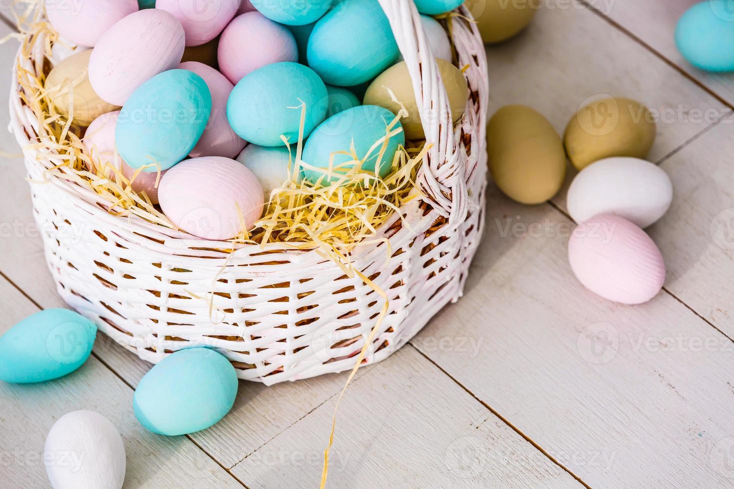 Easter eggs in nest on color wooden background photo