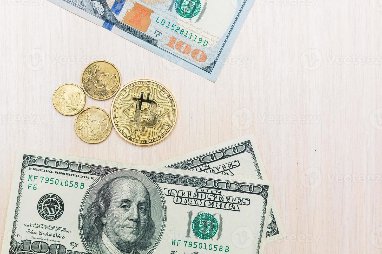 Coins of dollars euros bitcoins lying on a hundred dollar bill photo