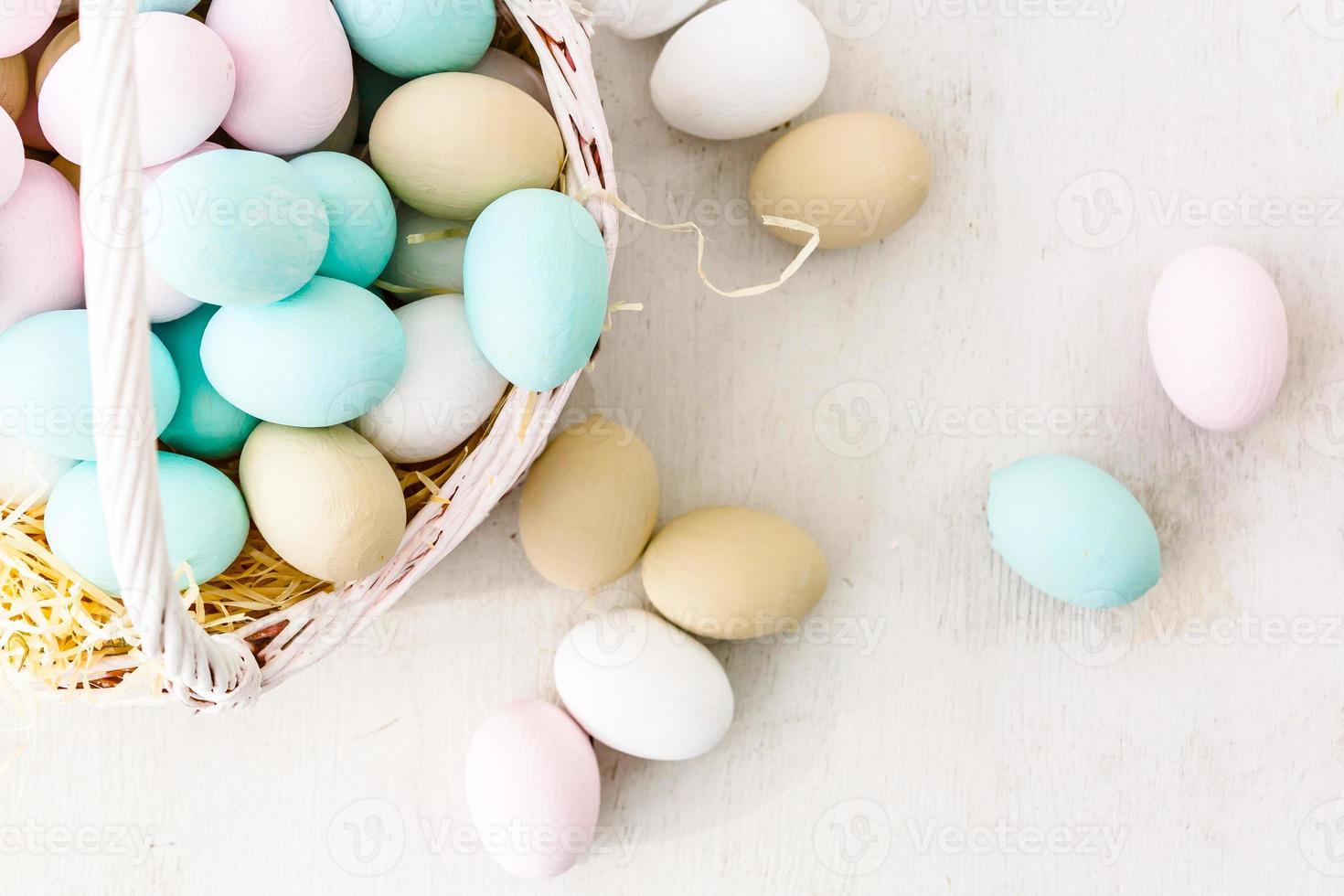 Easter eggs in nest on color wooden background photo