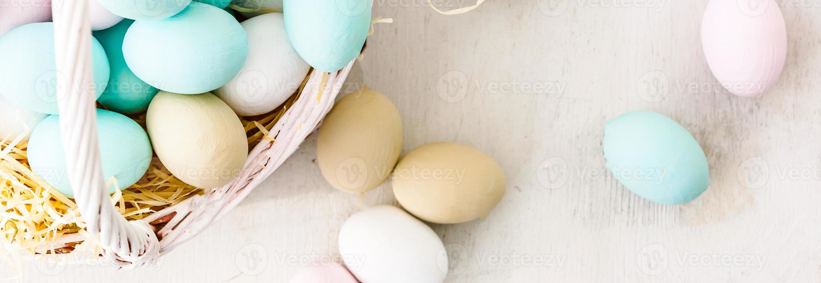 Easter eggs in nest on color wooden background photo