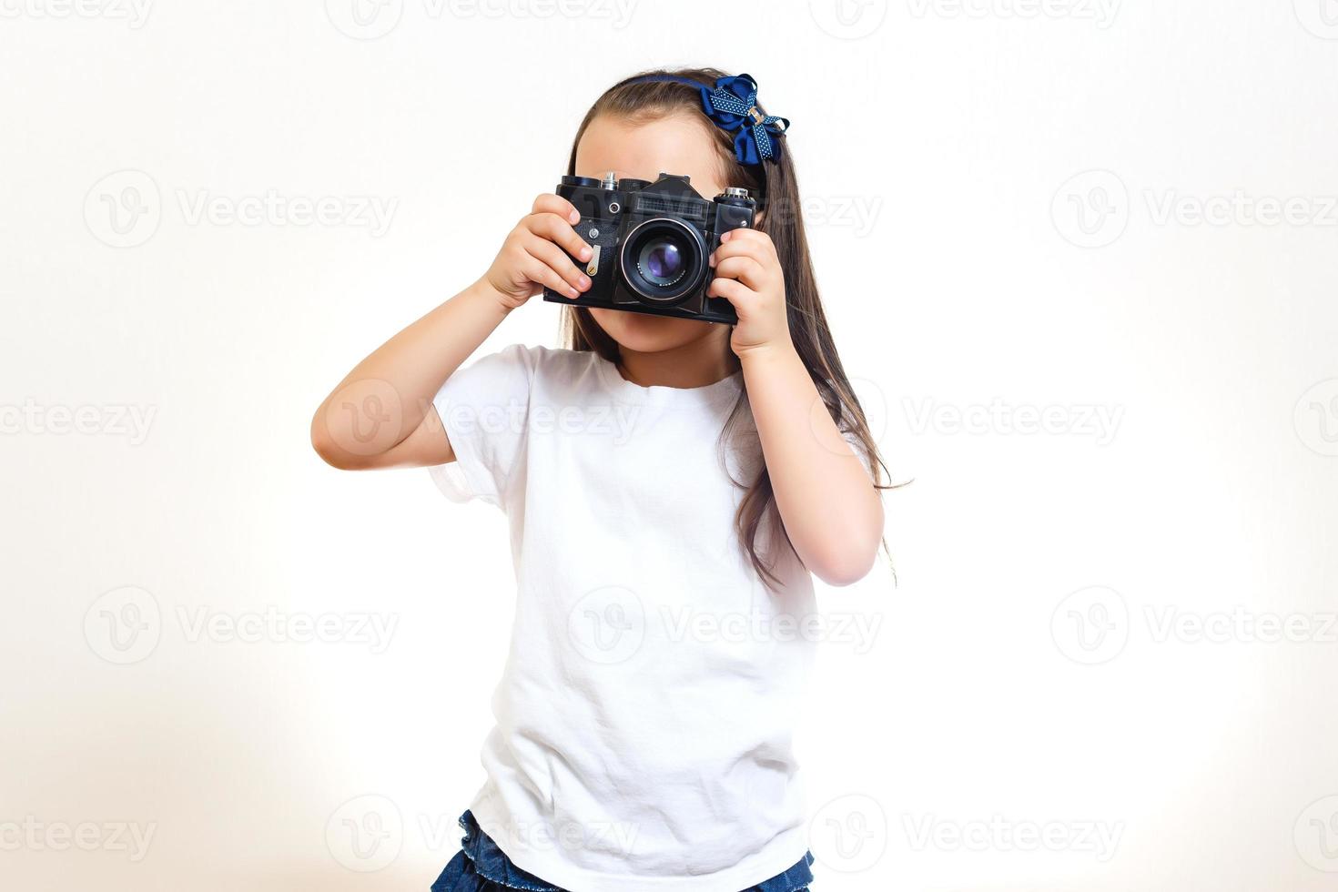 Girl taking a picture with a professional retro camera isolated on white photo