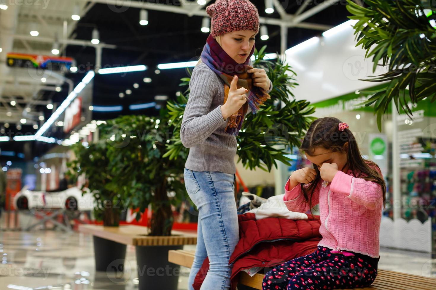 la niña llora y la madre regaña en el centro comercial foto