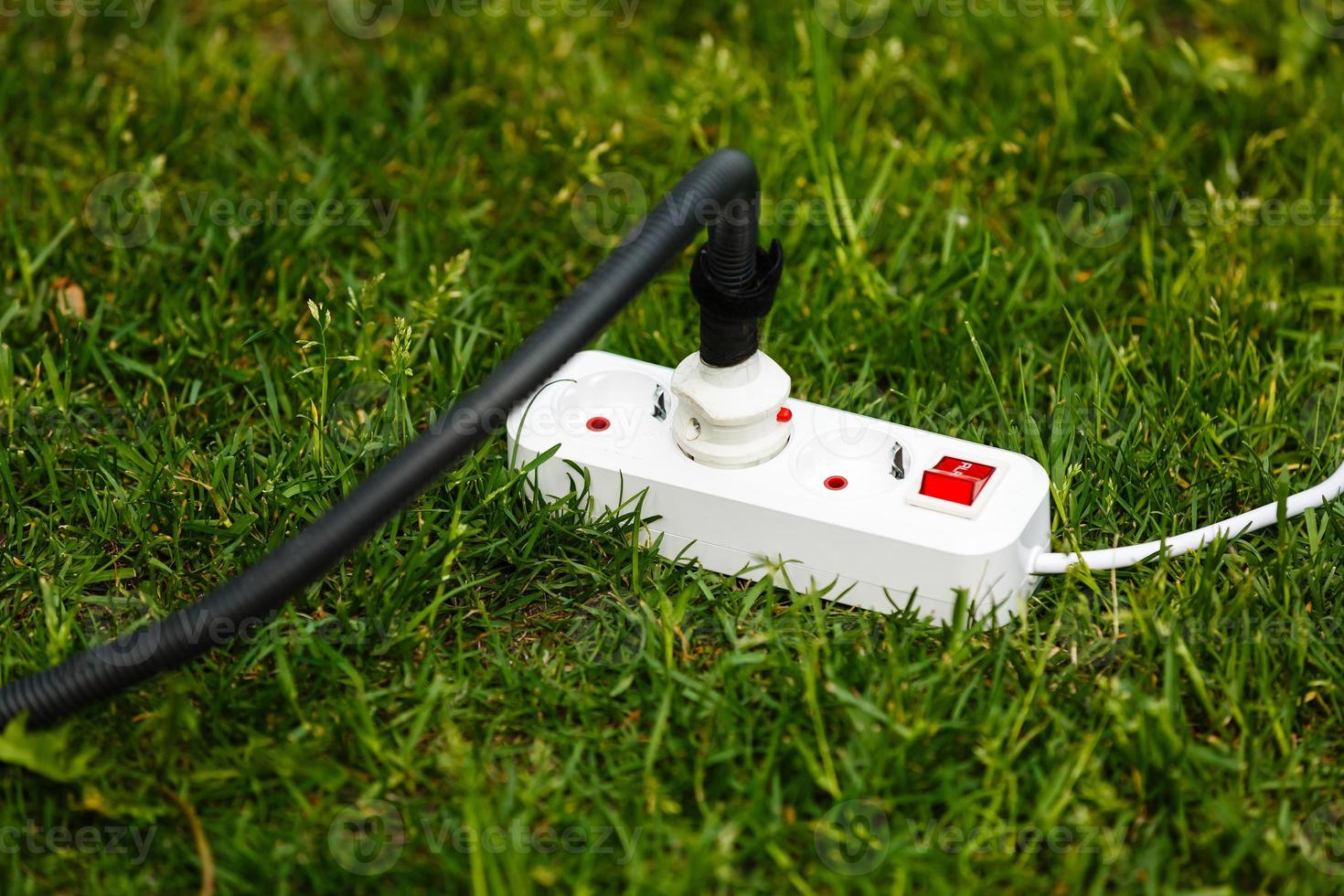 Electric power receptacle and plug on the grass photo