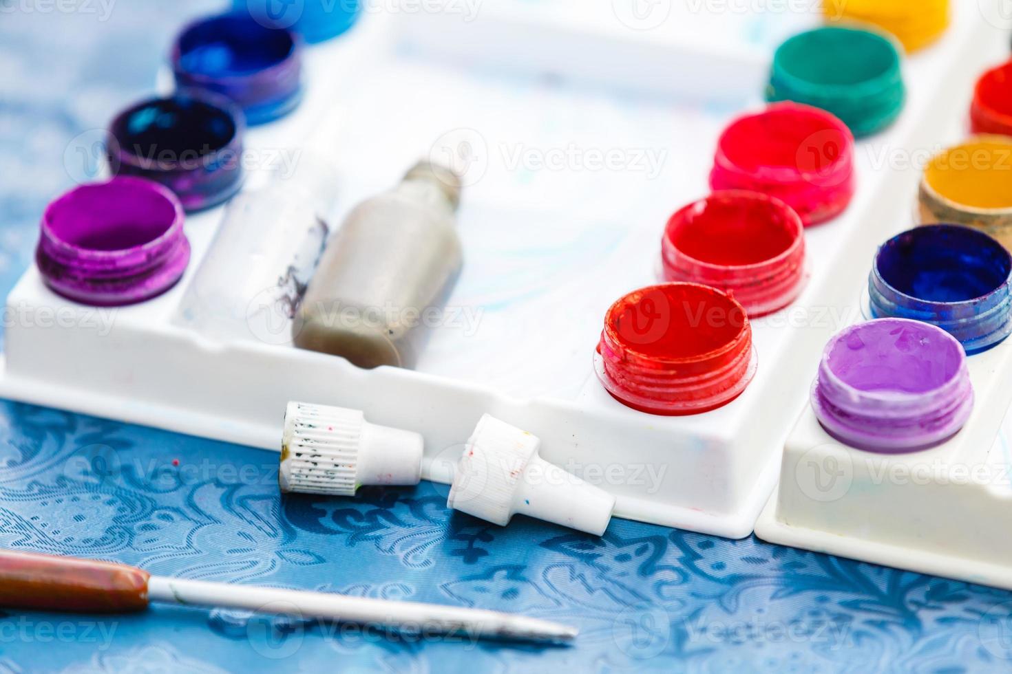 Clear plastic spoon for scooping share color posters in bottles for packing capacity color on the desktop, multi-colored poster paint bottle placed on the table without a mess. photo