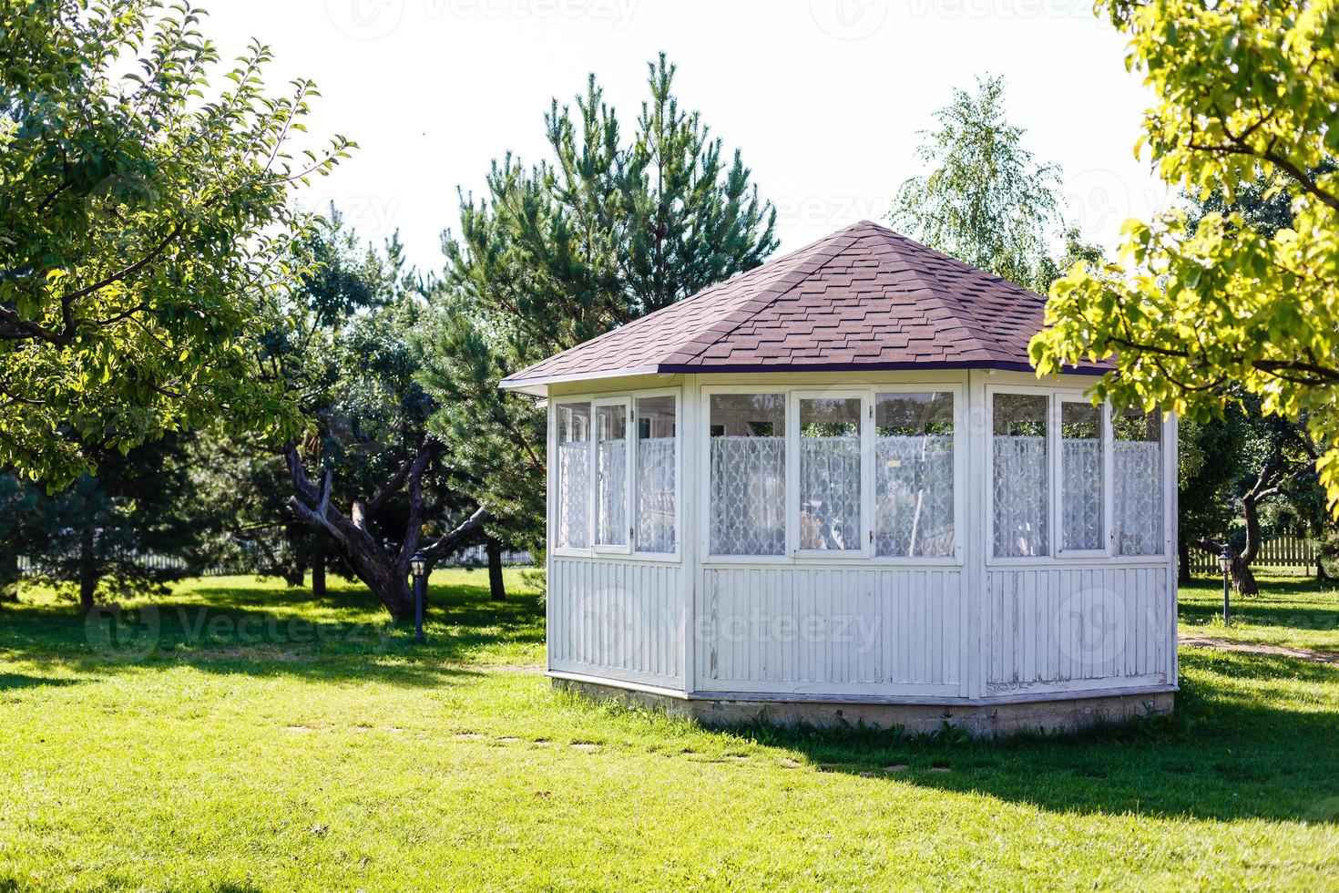 White pavilion in the garden. photo