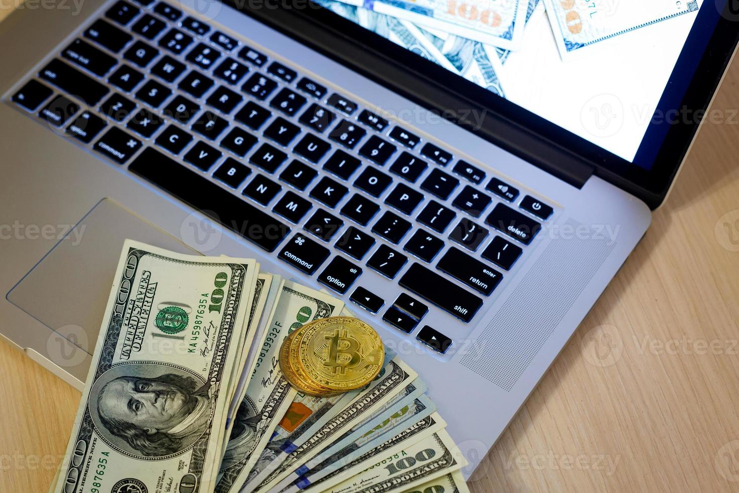 Bitcoin golden coins on a dollar banknotes office background  white laptop mobile photo