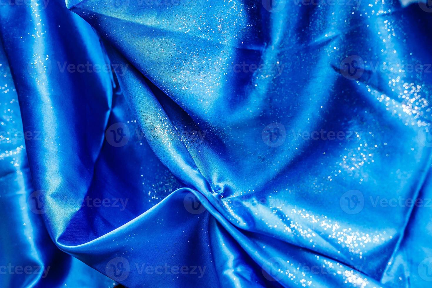 Silk fabric texture background covered with sequins blue photo