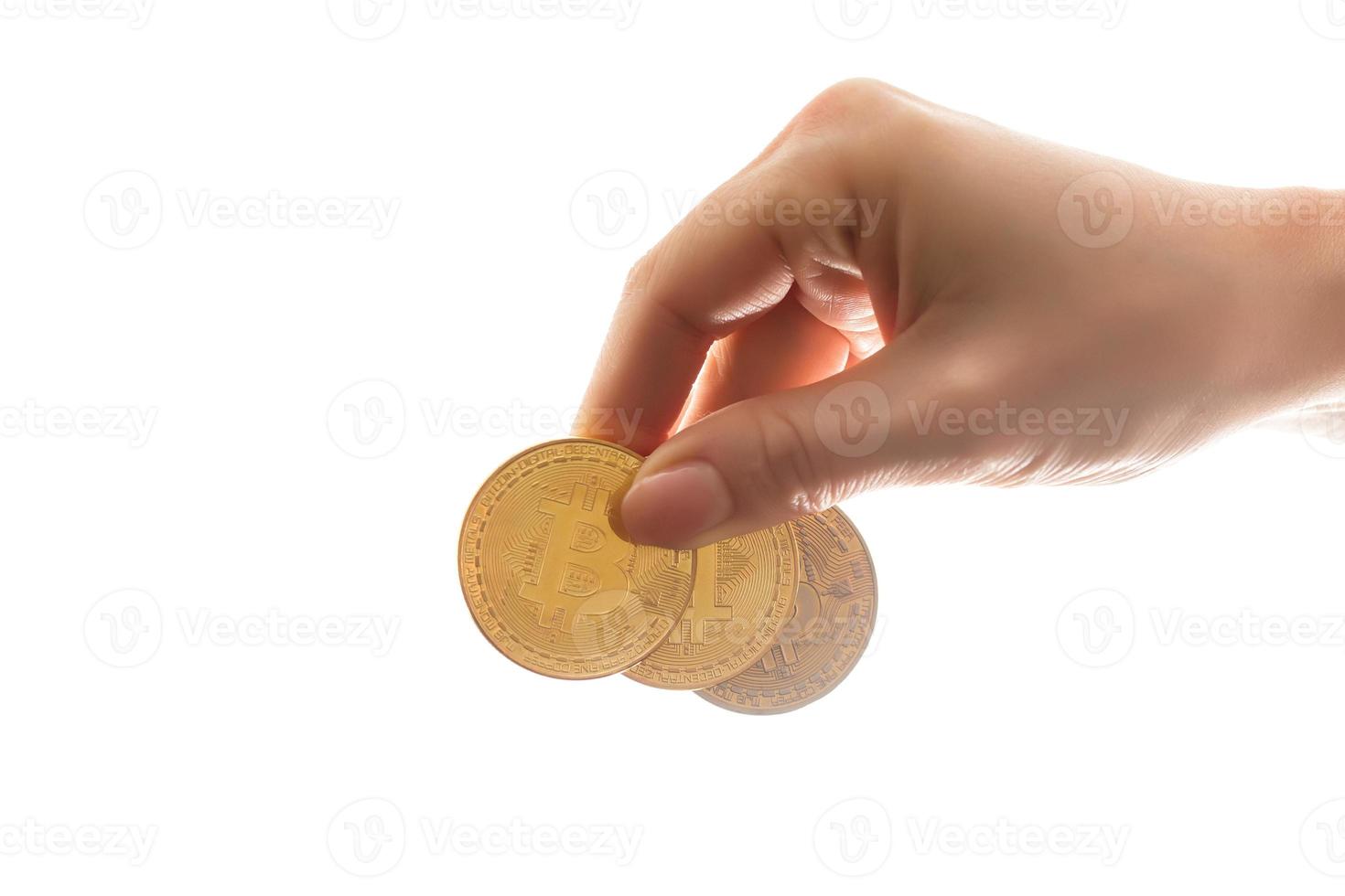 mano sostiene tres monedas de moneda digital bitcoin foto