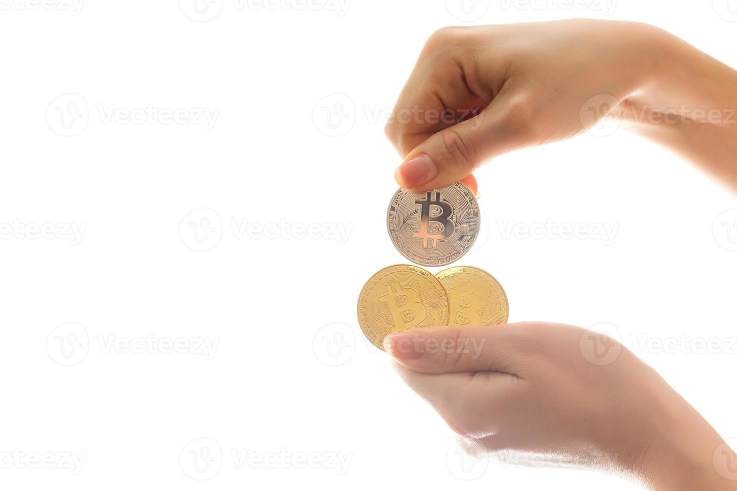 mano sostiene tres monedas de moneda digital bitcoin foto