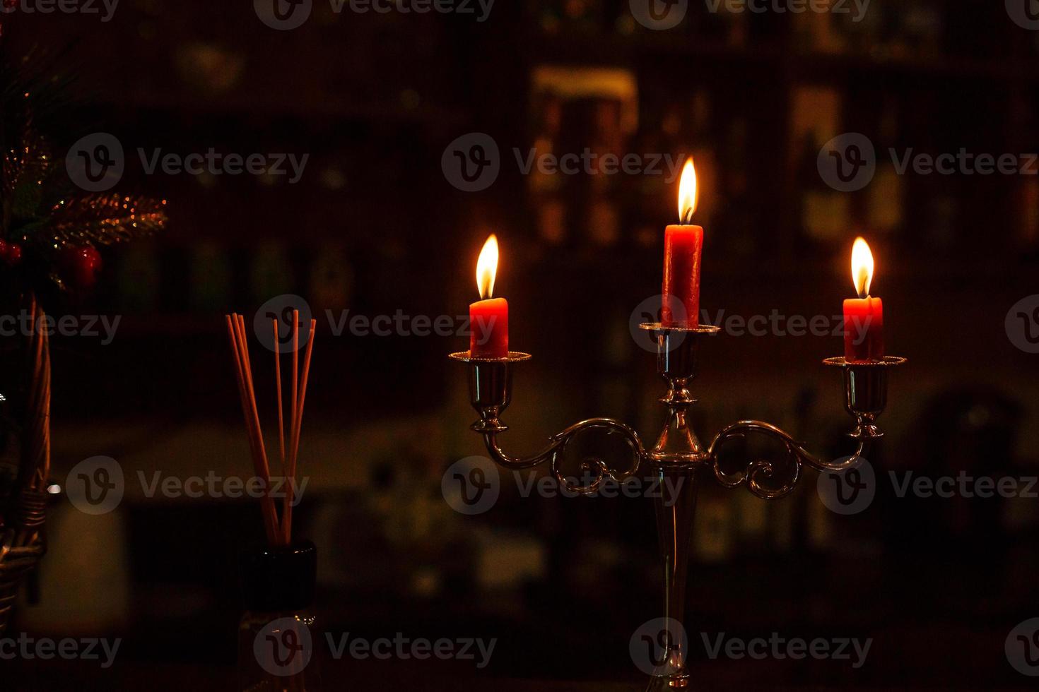 Old candlestick holder in front of a dark red background photo