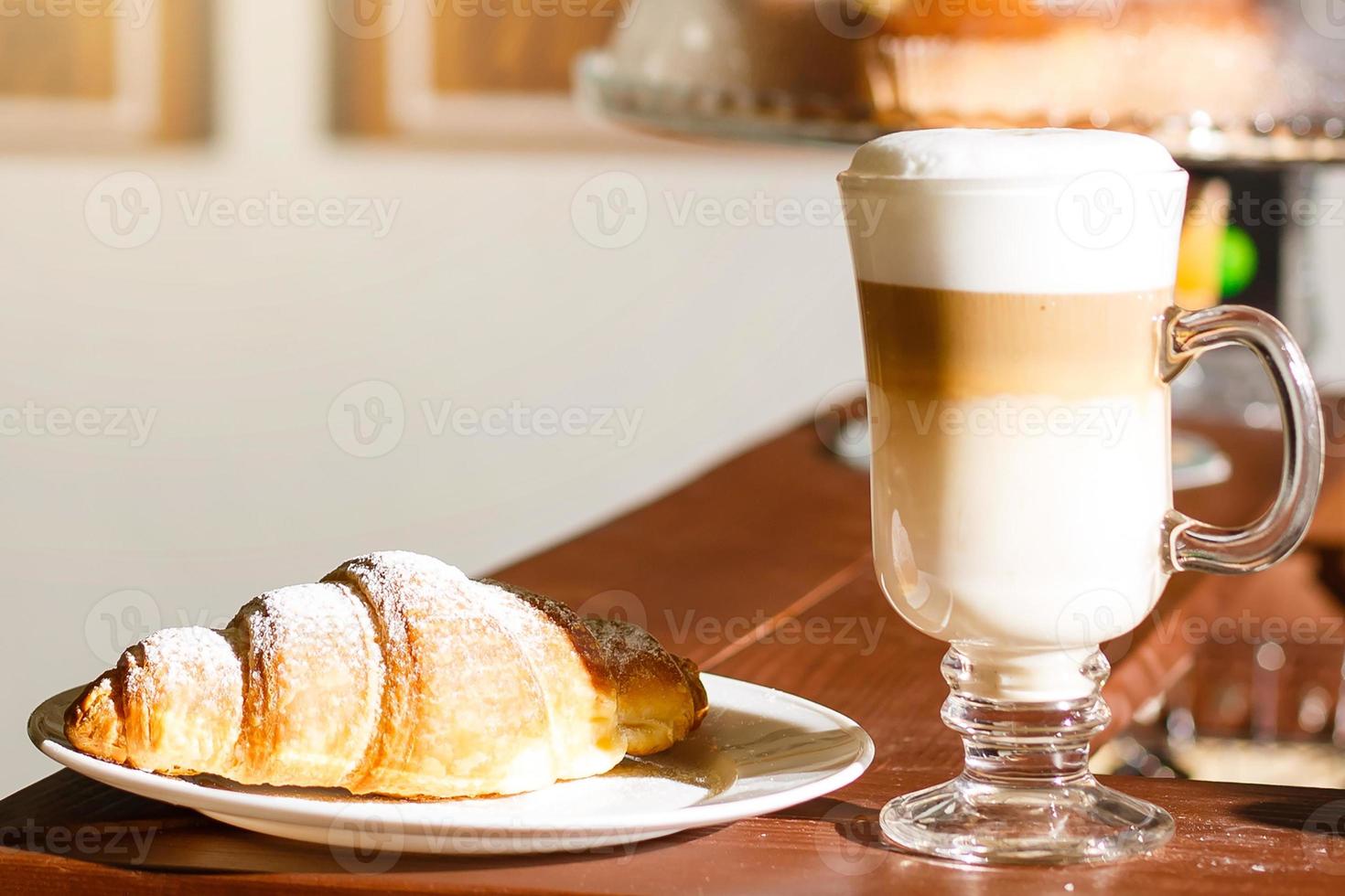 café con leche y croissant en una mesa de madera foto