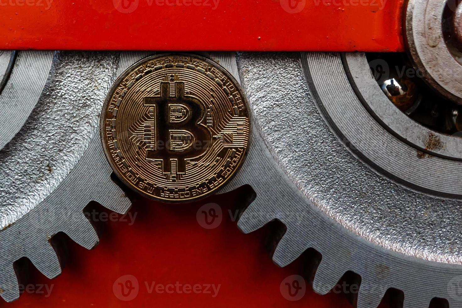 Gears and cogs close up and bitcoin coin photo