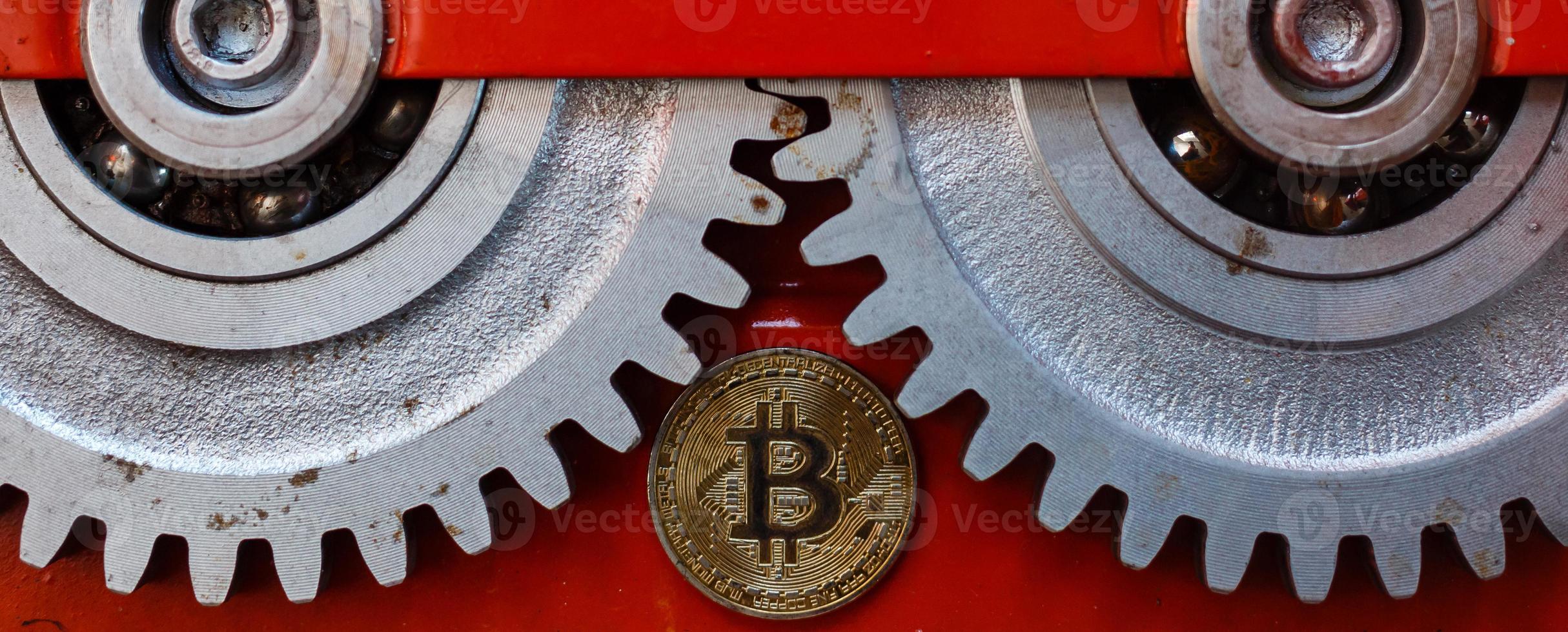 Gears and cogs close up and bitcoin coin photo