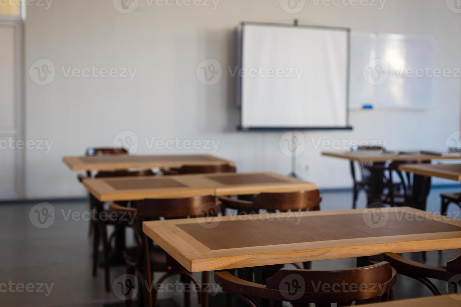 dentro del antiguo salón de clases con pizarra, pupitres y sillas. foto