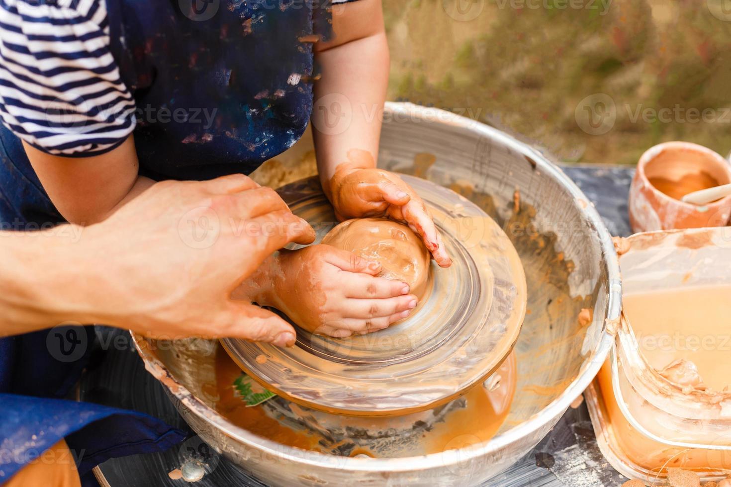 A close-up of the child learns to knead the clay photo