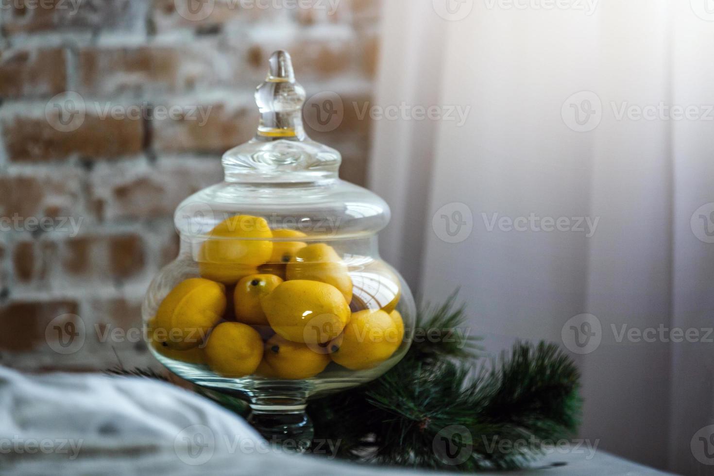 Lemons in a glass stand on a table photo