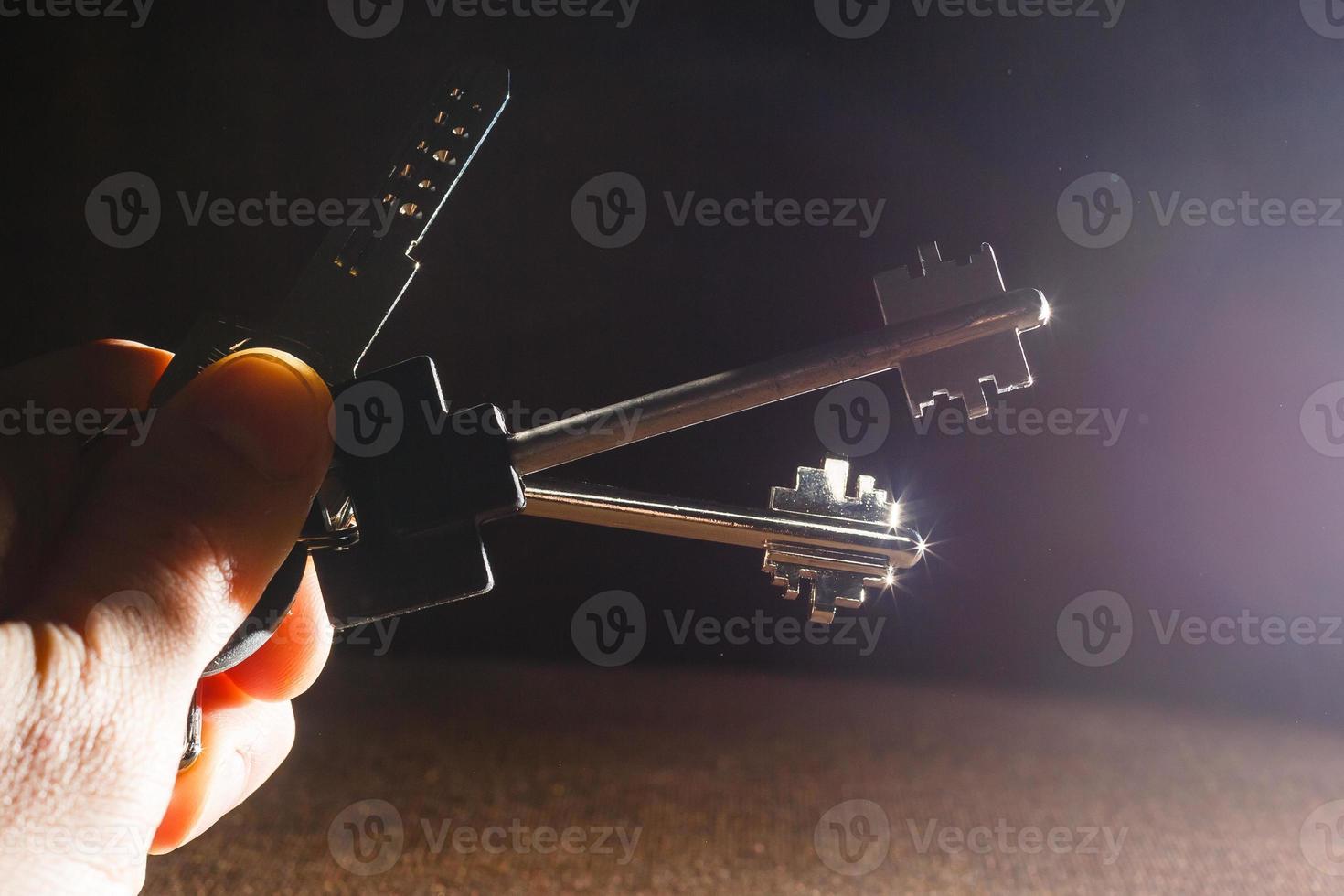 Key with key chain on hand on black background photo