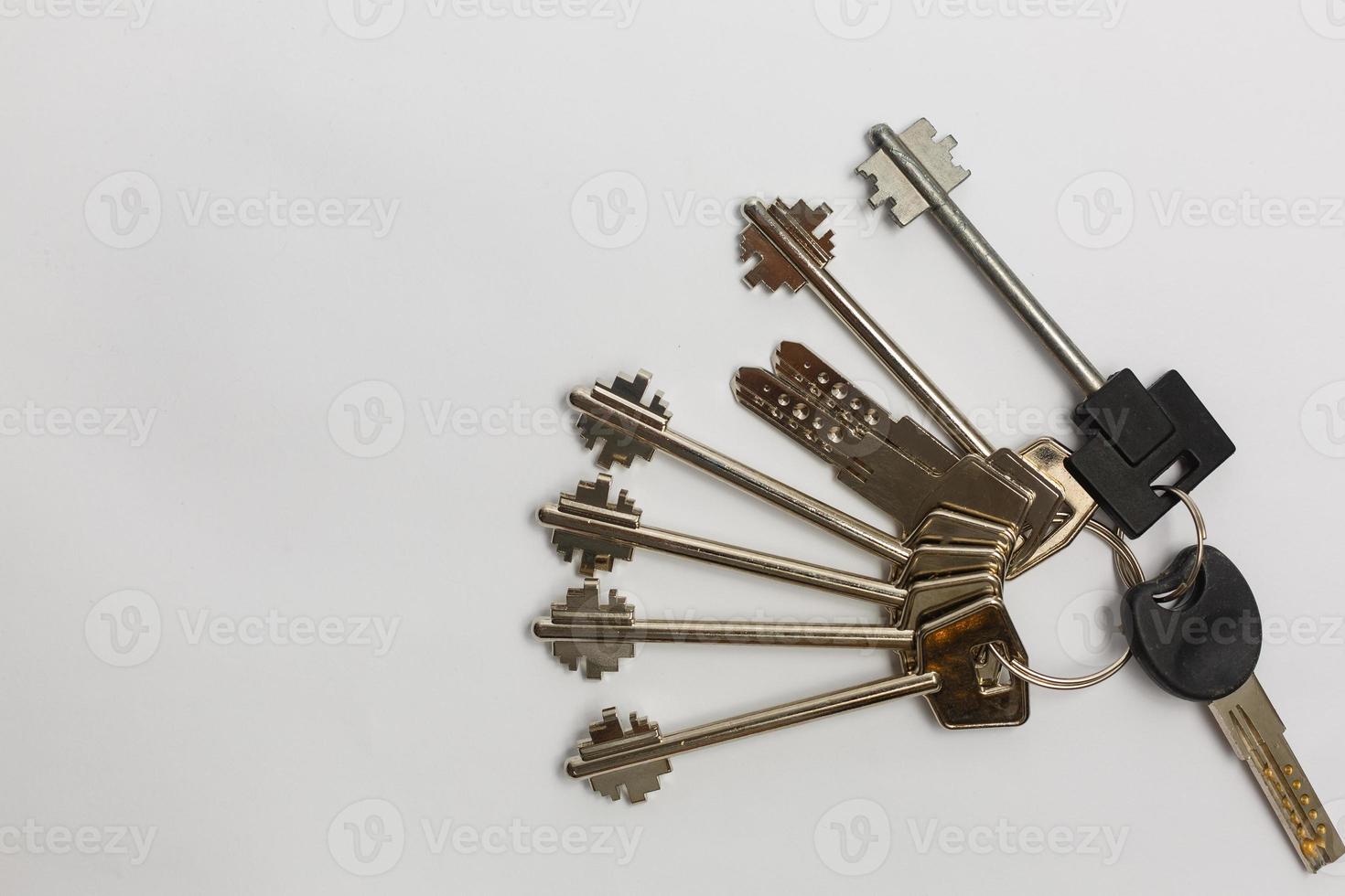 Bunch of keys with house shaped key ring on a rustic wooden table photo