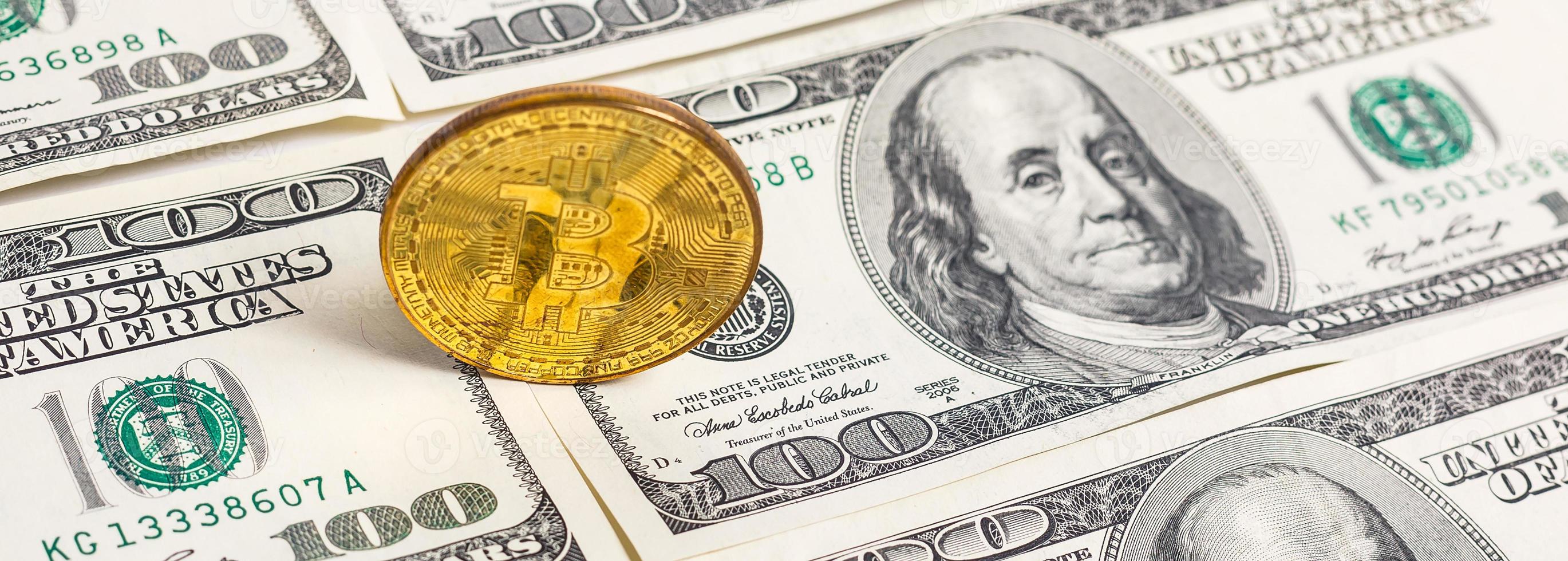 Golden bitcoin coin on us dollars close up photo