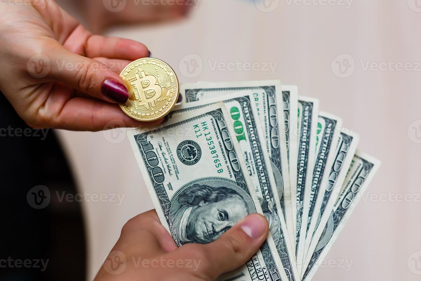 Golden bitcoins on us dollars in the hands electronic money exchange concept photo