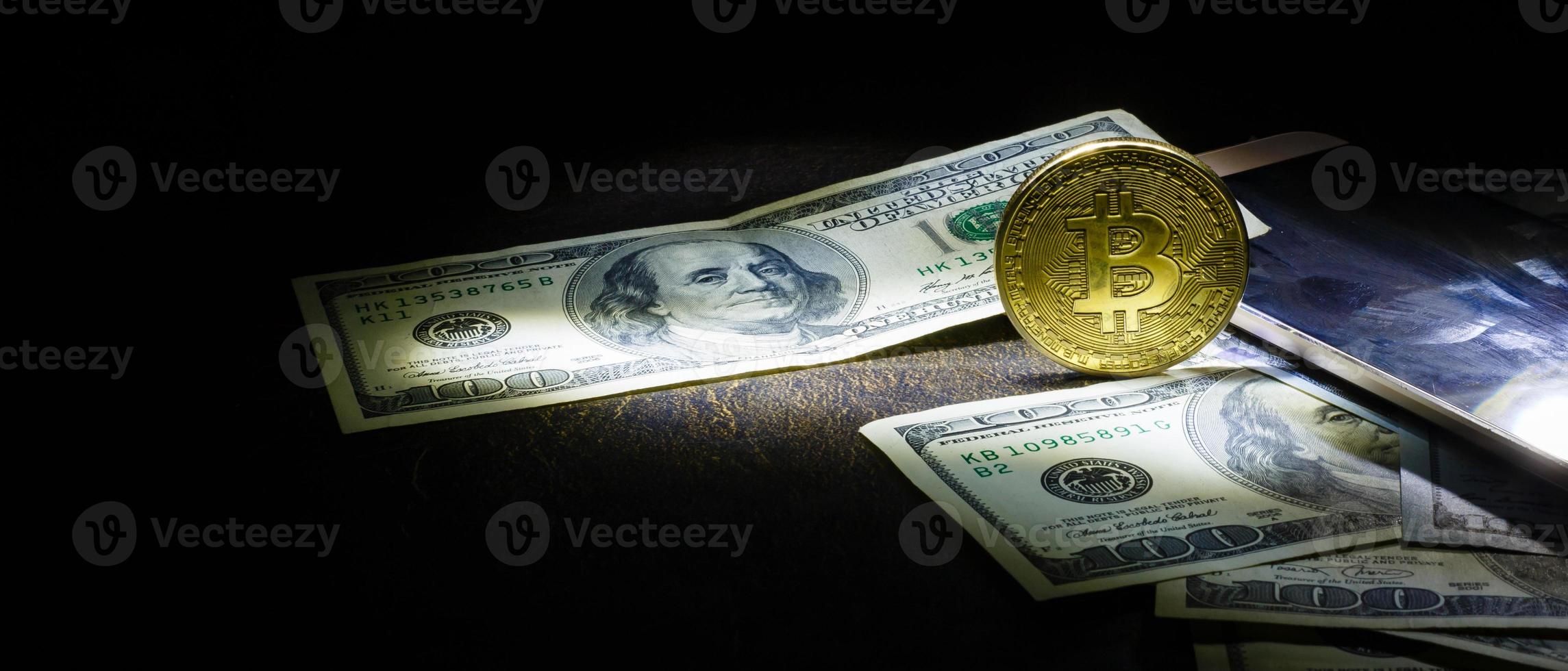 bitcoin dollars on a black background Golden bitcoins with the spotlight photo
