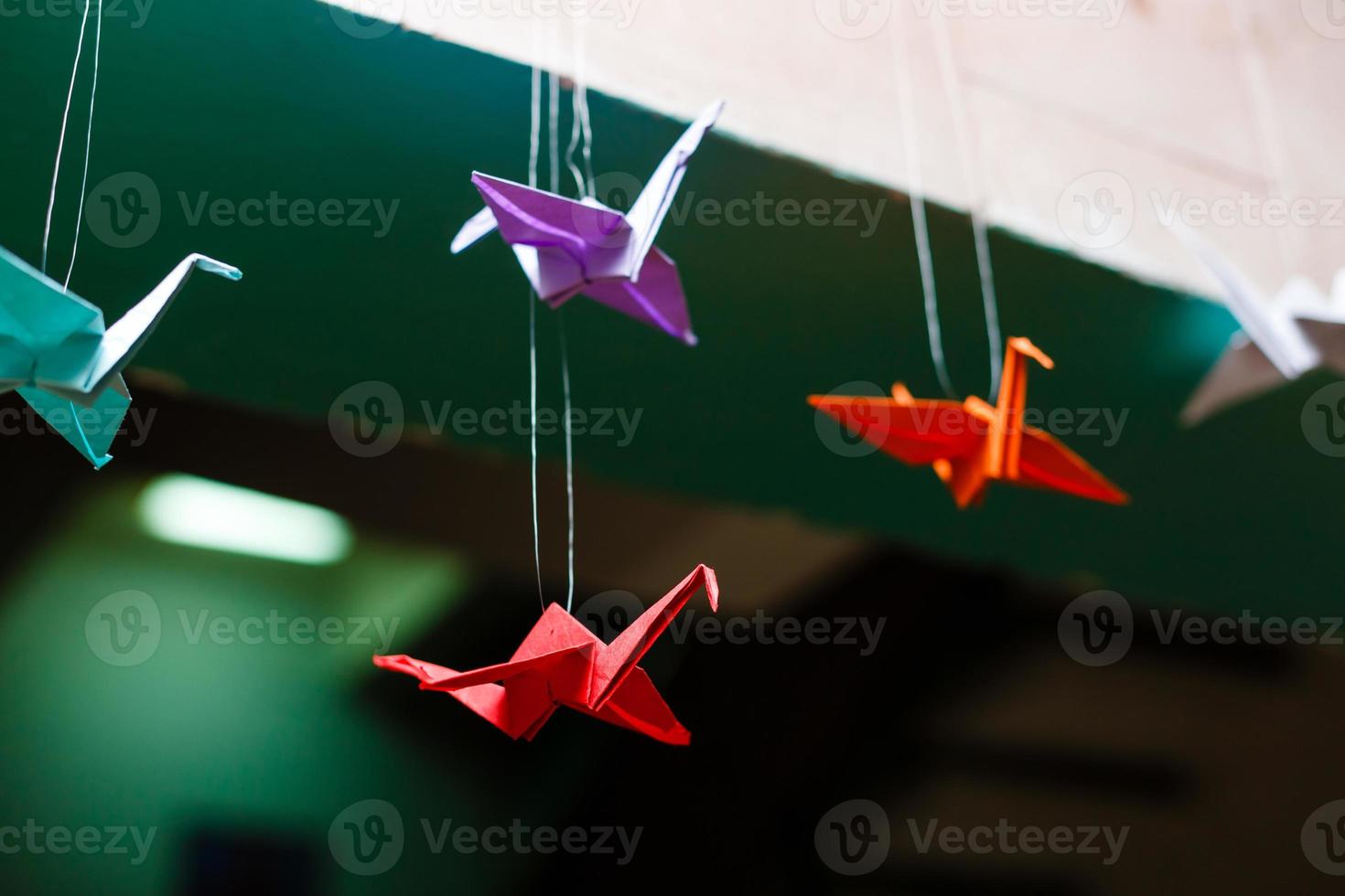 Colorful handmade origami cranes or fantasy birds made of folded paper with complementary photo