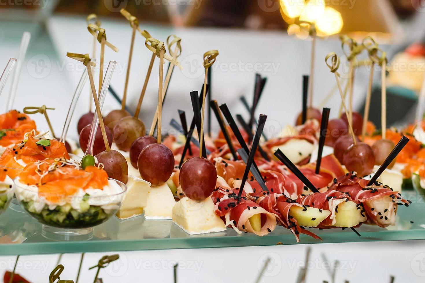 Beautifully decorated catering banquet table with burgers profiteroles salads and cold snacks photo