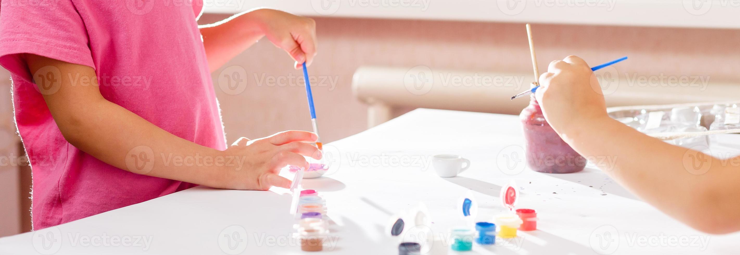 dos lindas hermanitas dibujando con colores en una guardería niños creativos pintando juntos foto