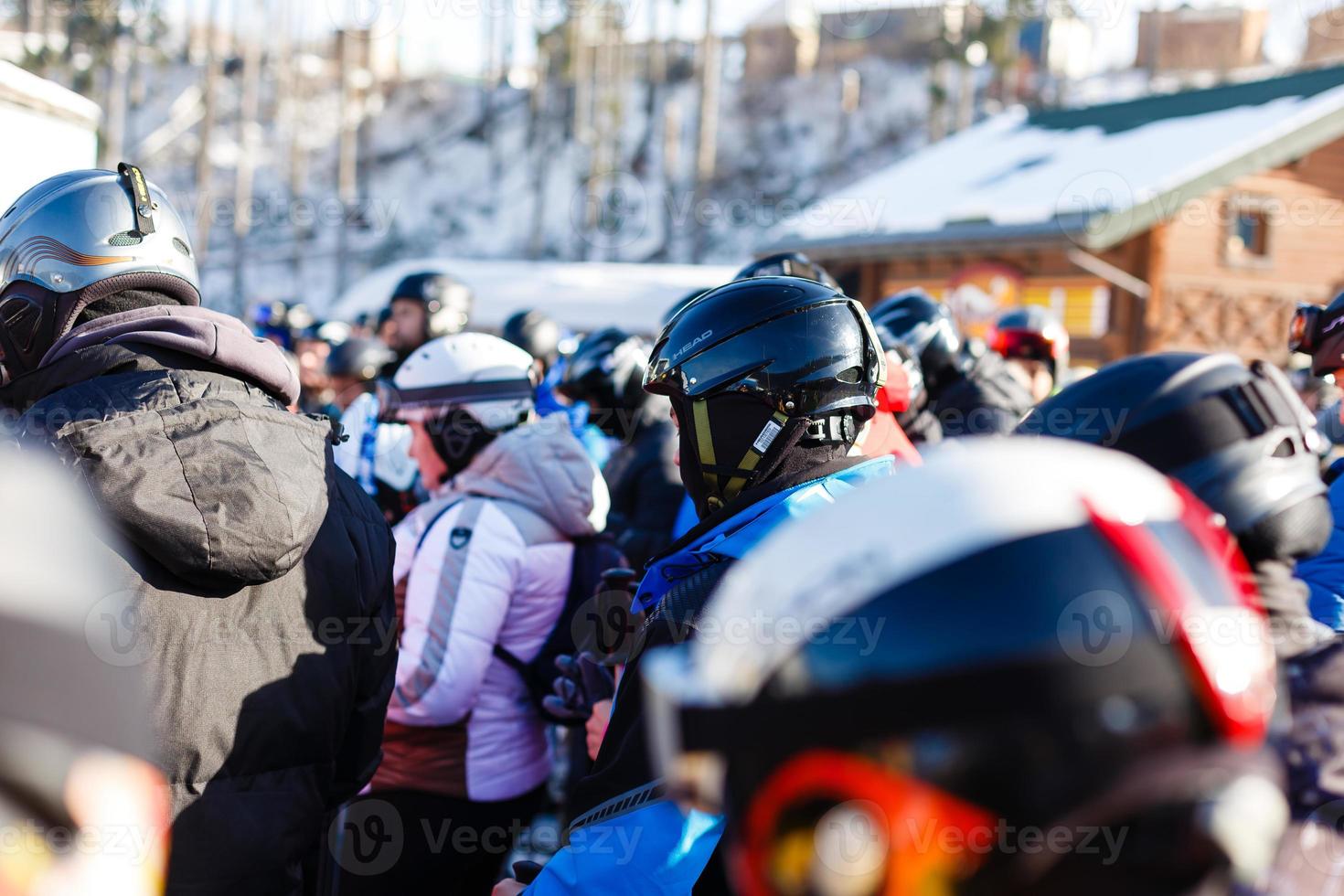 People at ski lift, line of skiers and snowboarders photo