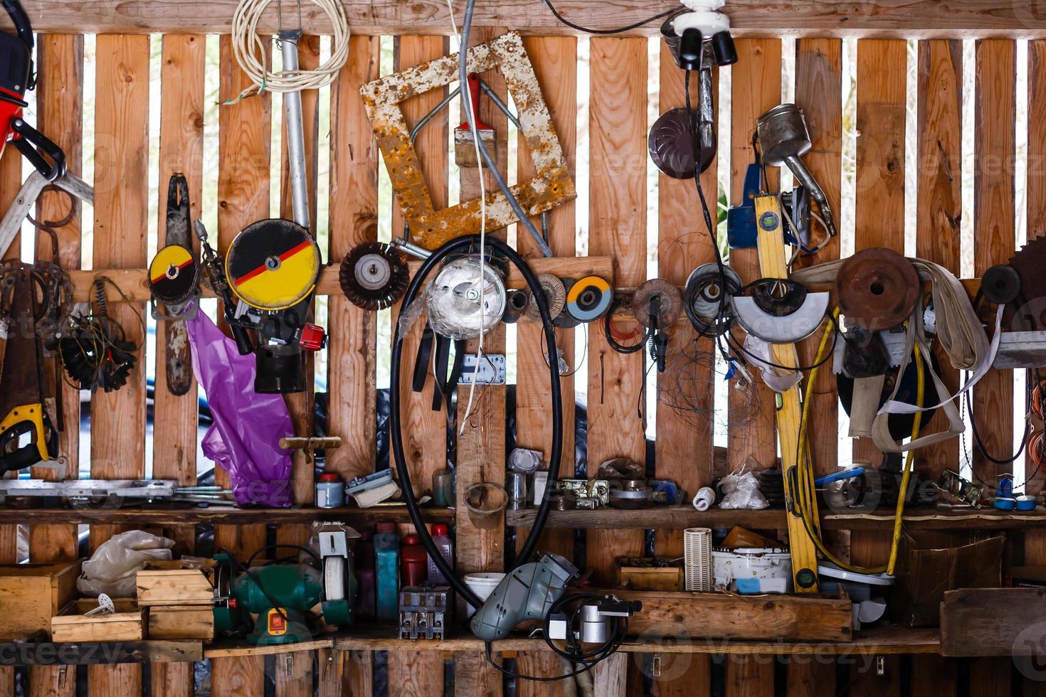 variedad de herramientas de bricolaje colgadas en un armario de madera contra una pared foto