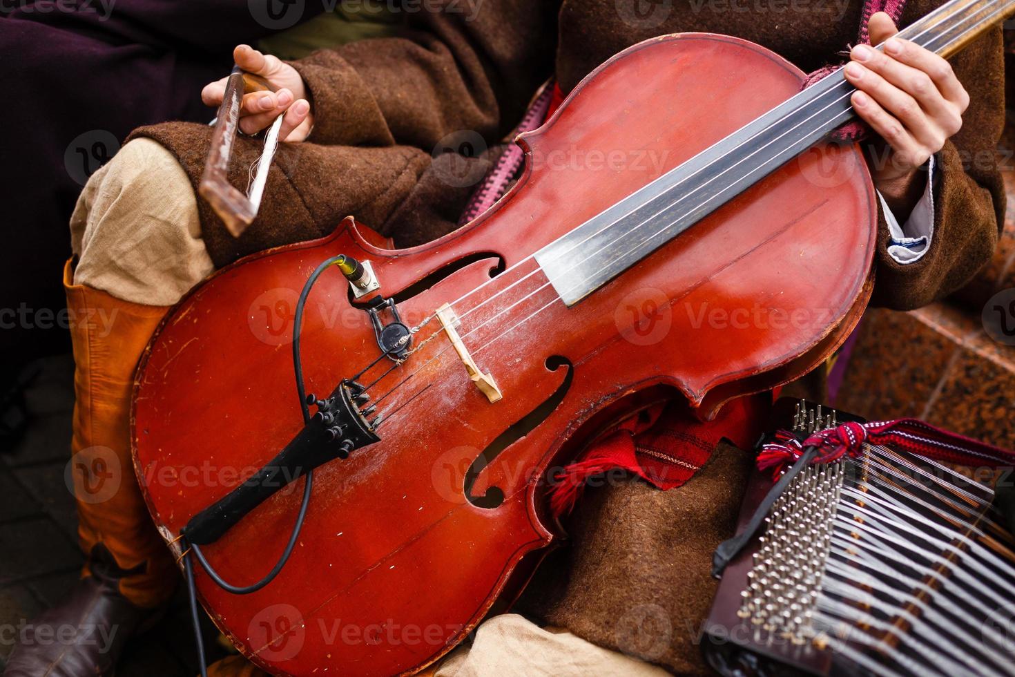 Man playing for cello on dark background. Music conception photo