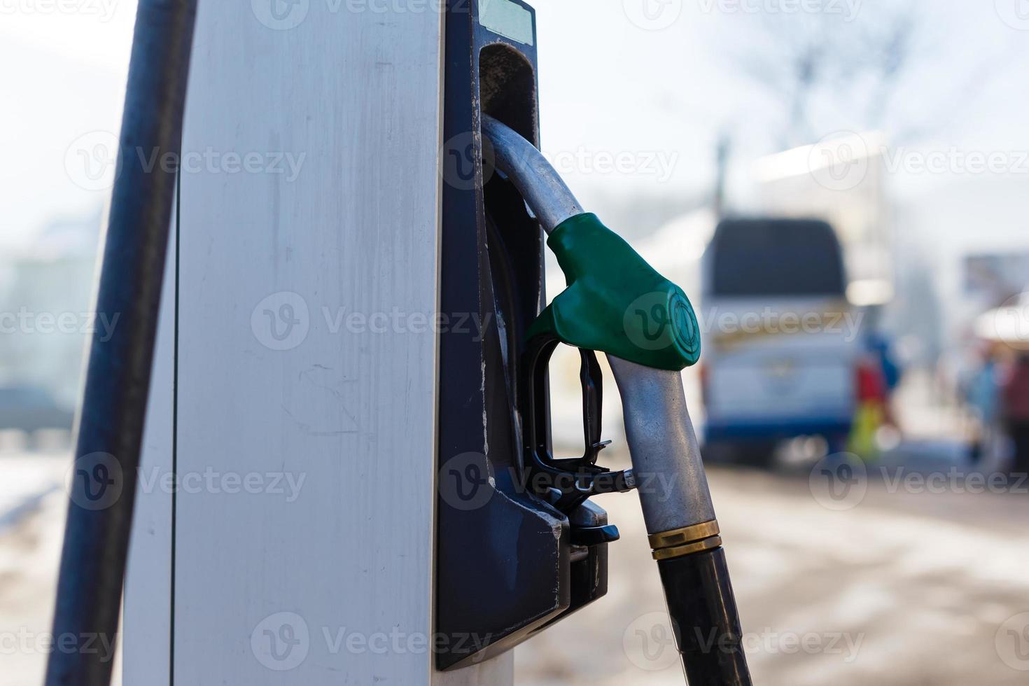 Fuel Dispenser with gas nozzle in gasoline station on winter season photo
