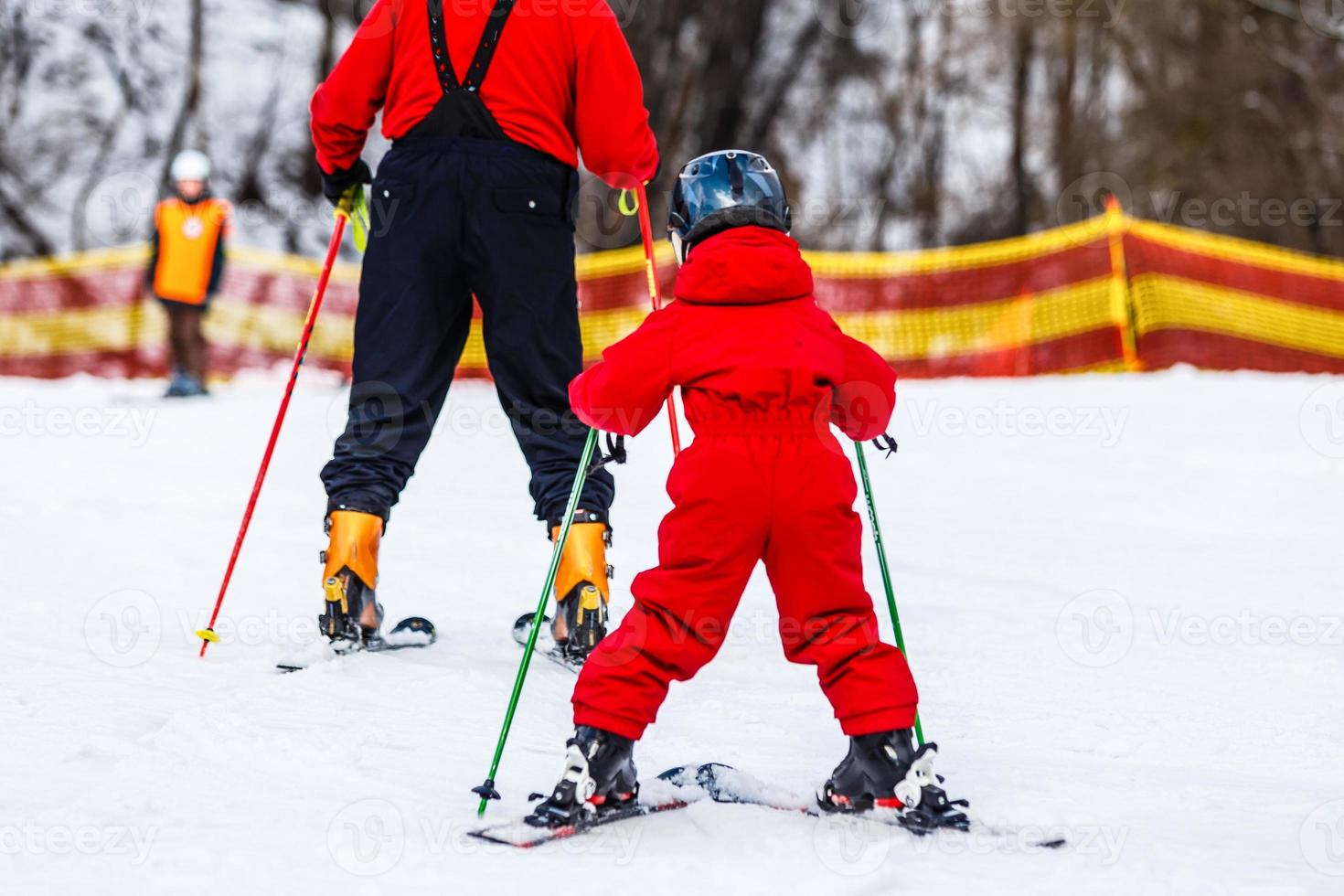 Group of skiers in red lifting up to the top of the hill photo