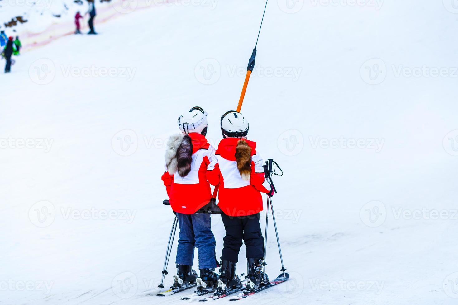 children on a ski lift, ski-lift and snow-capped mountains. photo