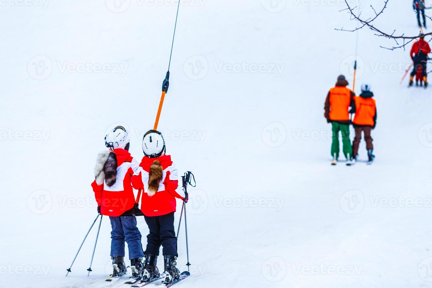 children on a ski lift, ski-lift and snow-capped mountains. photo