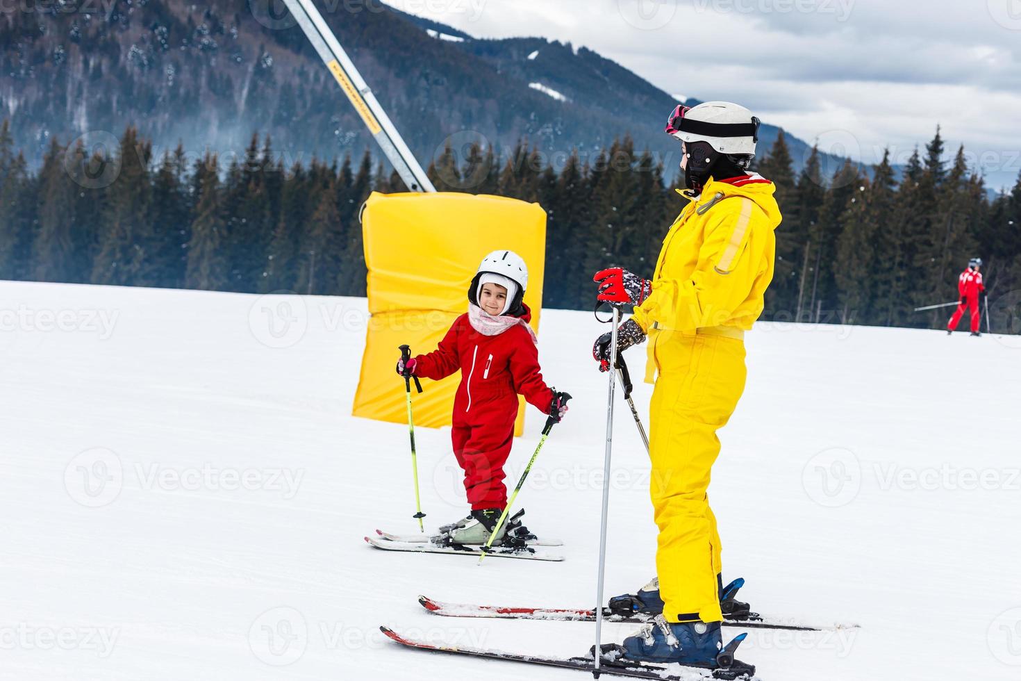 Little girl and a woman skier are going to ski photo