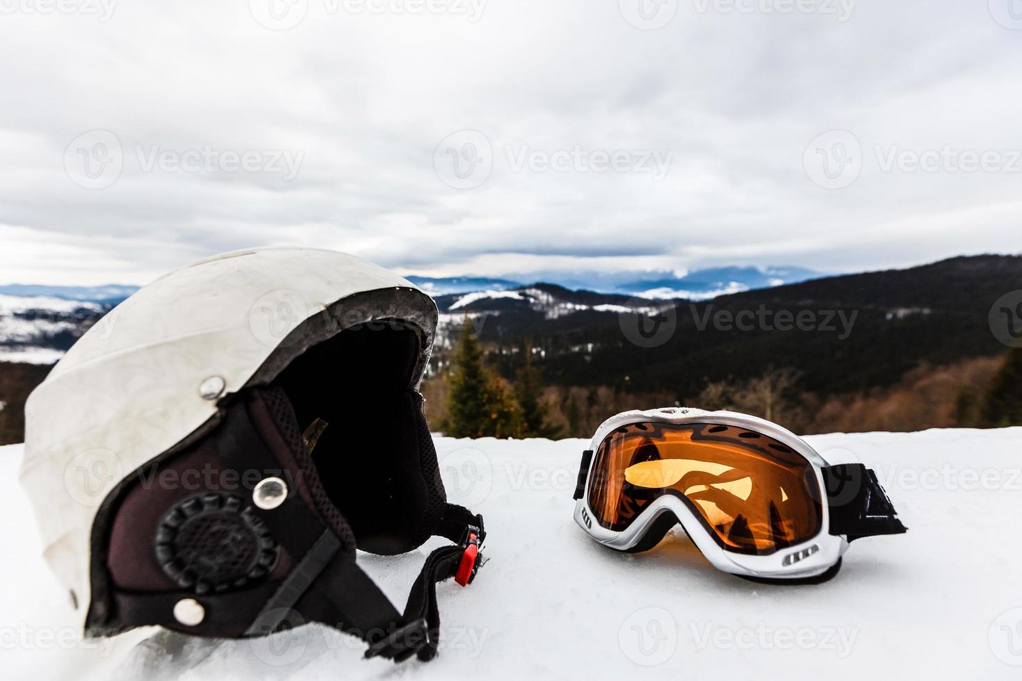 Ski helmet and ski goggles lie in the snow photo
