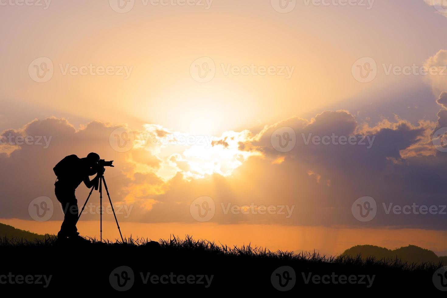 la silueta de un fotógrafo profesional se centra en disparar en un hermoso prado. foto