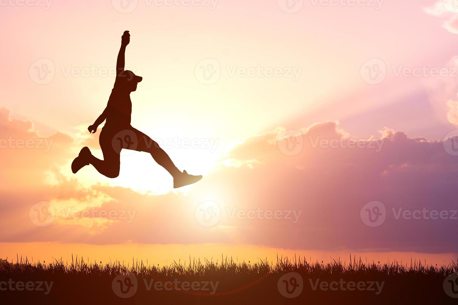 Silhouette. Man jumping happily in the meadow. photo