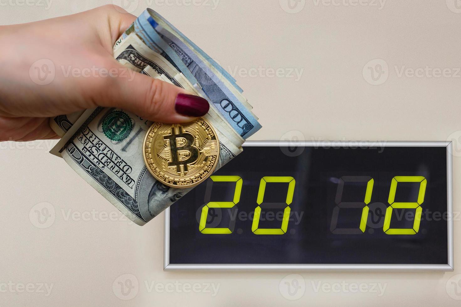 moneda de bitcoin dorada en la mano de la mujer en el espacio de copia de fondo de billetes de dólar estadounidense borroso 2018, perro de tierra foto