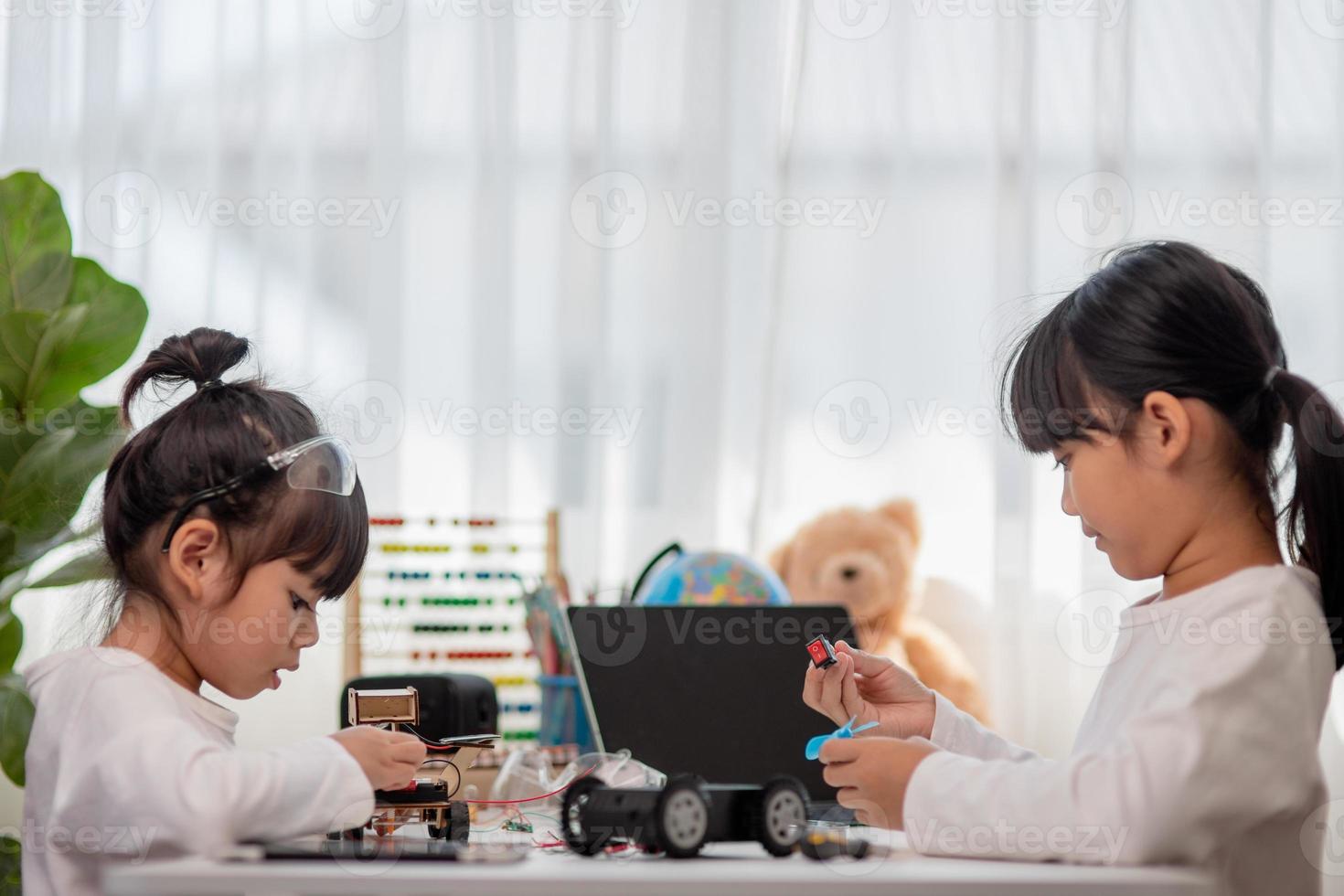 Asia students learn at home in coding robot cars and electronic board cables in STEM, STEAM, mathematics engineering science technology computer code in robotics for kids concept. photo