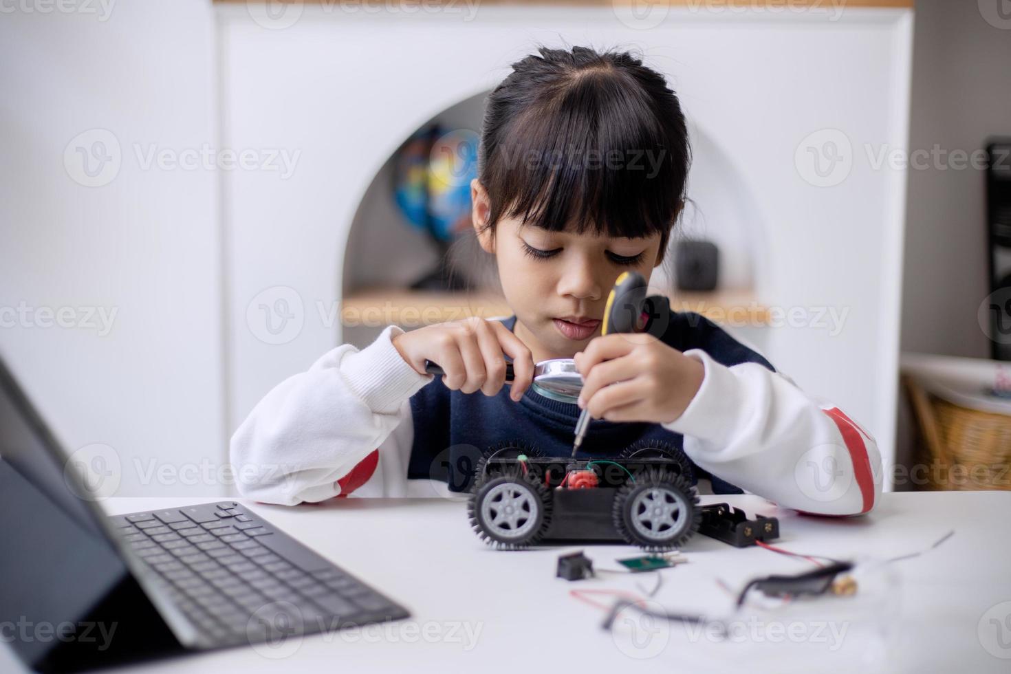 los estudiantes de asia aprenden en casa a codificar autos robot y cables de tableros electrónicos en tallo, vapor, ingeniería matemática, ciencia, tecnología, código de computadora en robótica para el concepto de niños foto