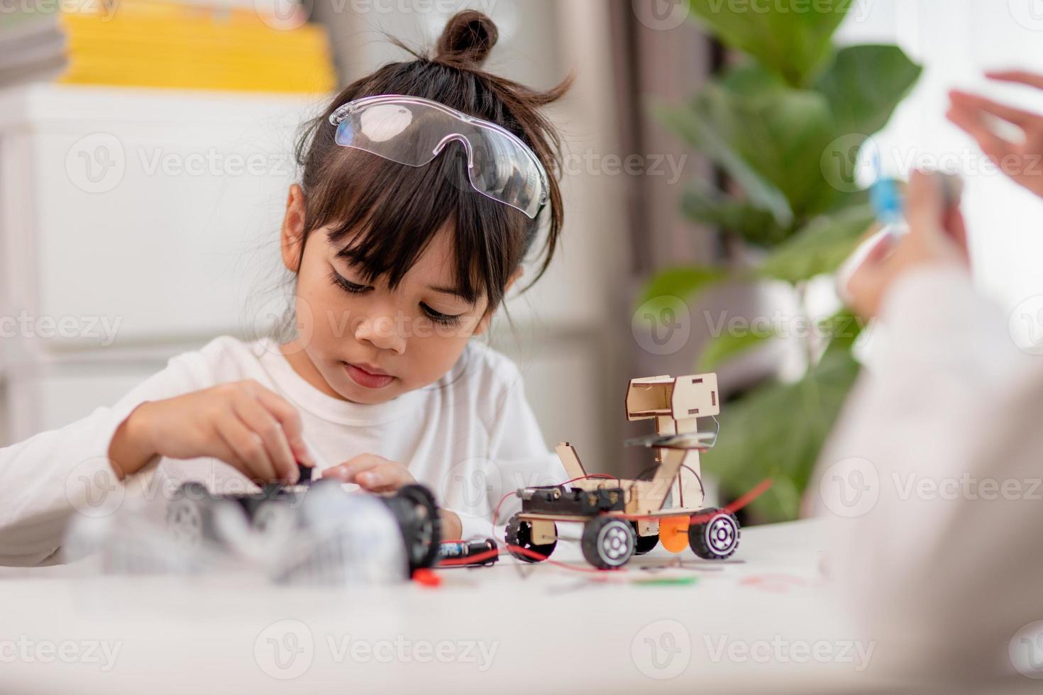 Asia students learn at home in coding robot cars and electronic board cables in STEM, STEAM, mathematics engineering science technology computer code in robotics for kids concept. photo