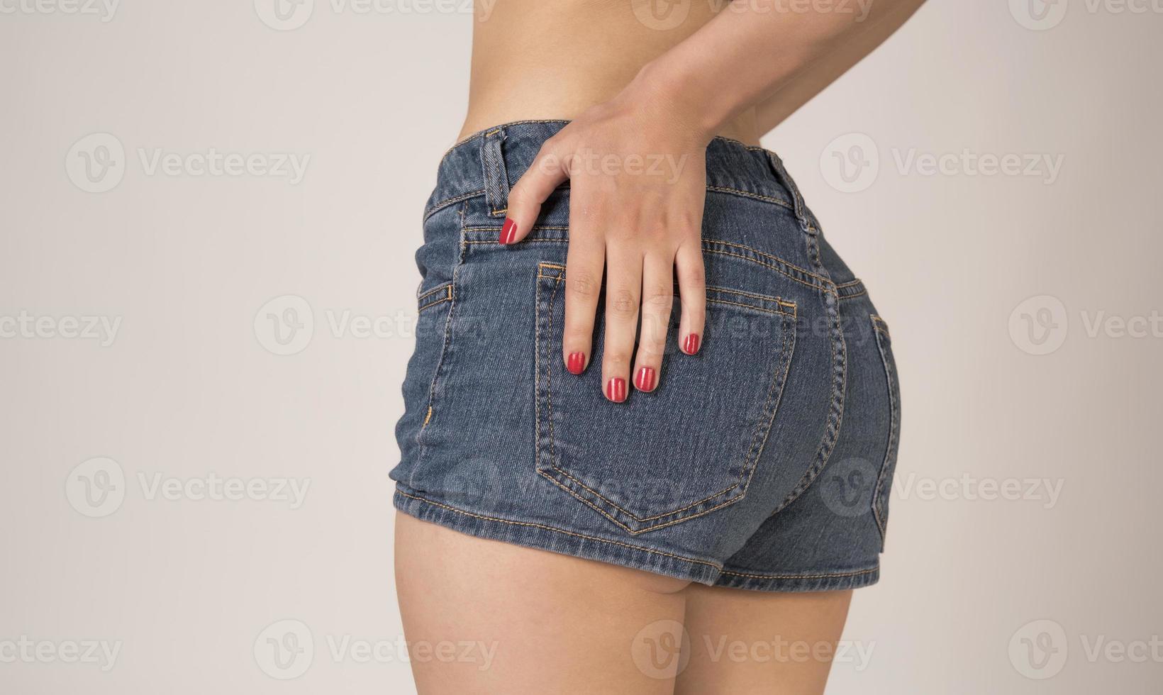 Sexy woman in fashion blue jeans shorts. Perfect hot booty and erotic curves hips. Good body shapes whithout cellulite. Sport and diet. photo