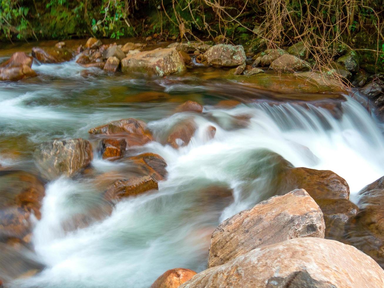 hermosa cascada con aguas cristalinas borrosas fotografiadas en larga exposición foto