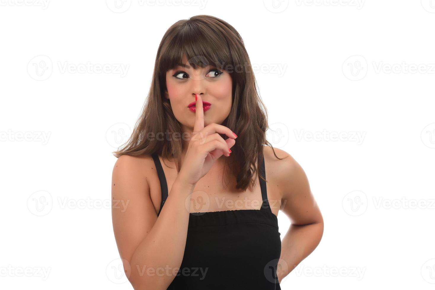 Finger on lips - silent gesture, Woman holding her finger to her lips in a gesture for silence. photo