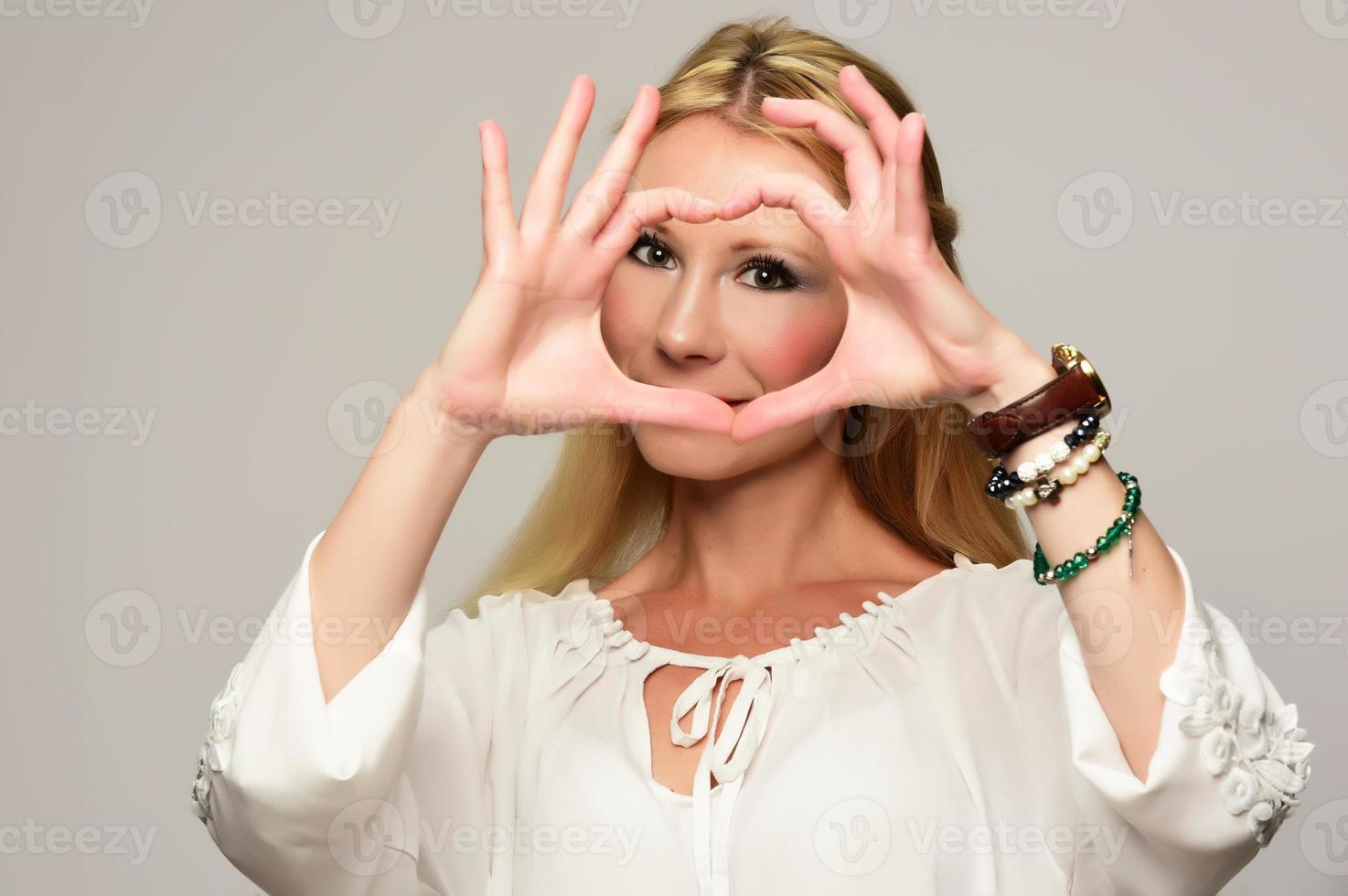 Portrait Of Beautiful Happy Woman Holding Heart Shaped Hands photo