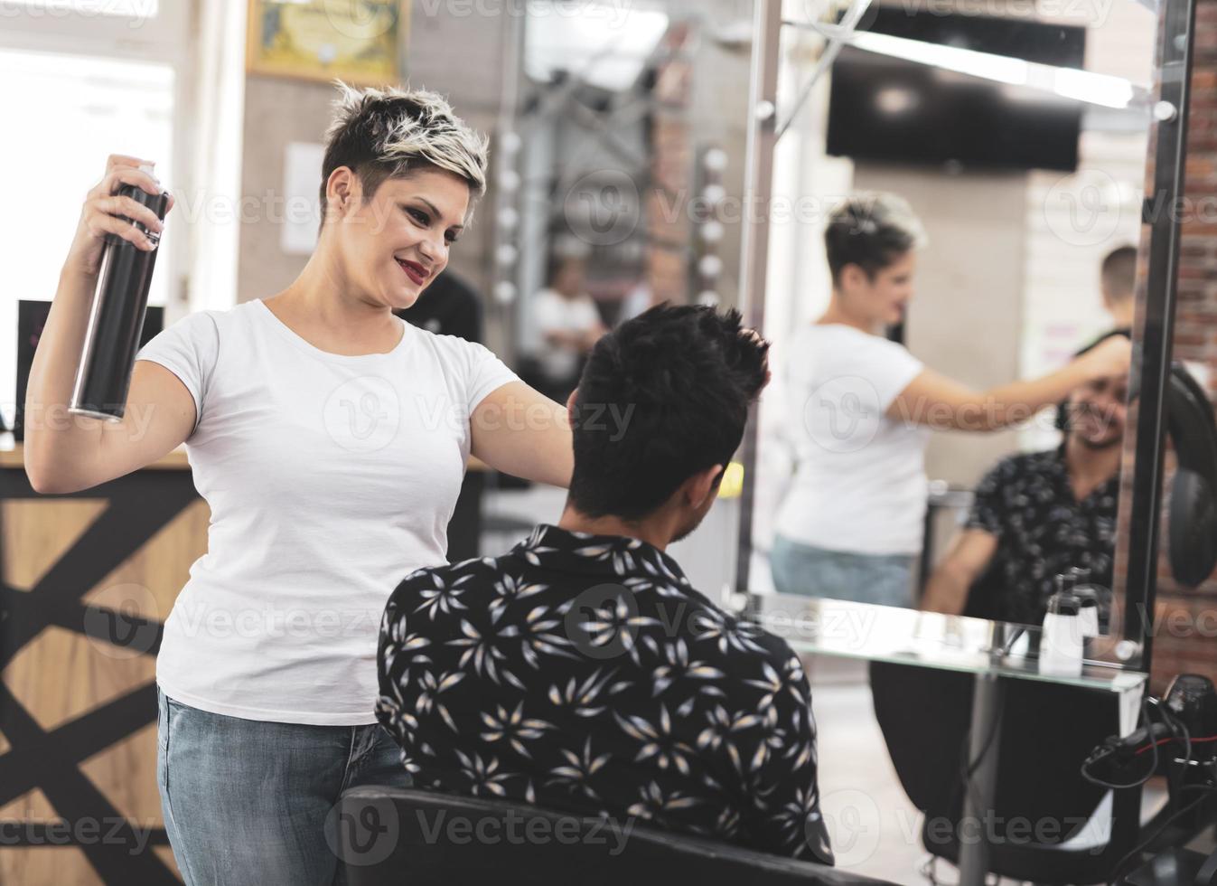 Professional hairdresser is cutting men's hair in beauty salon. photo