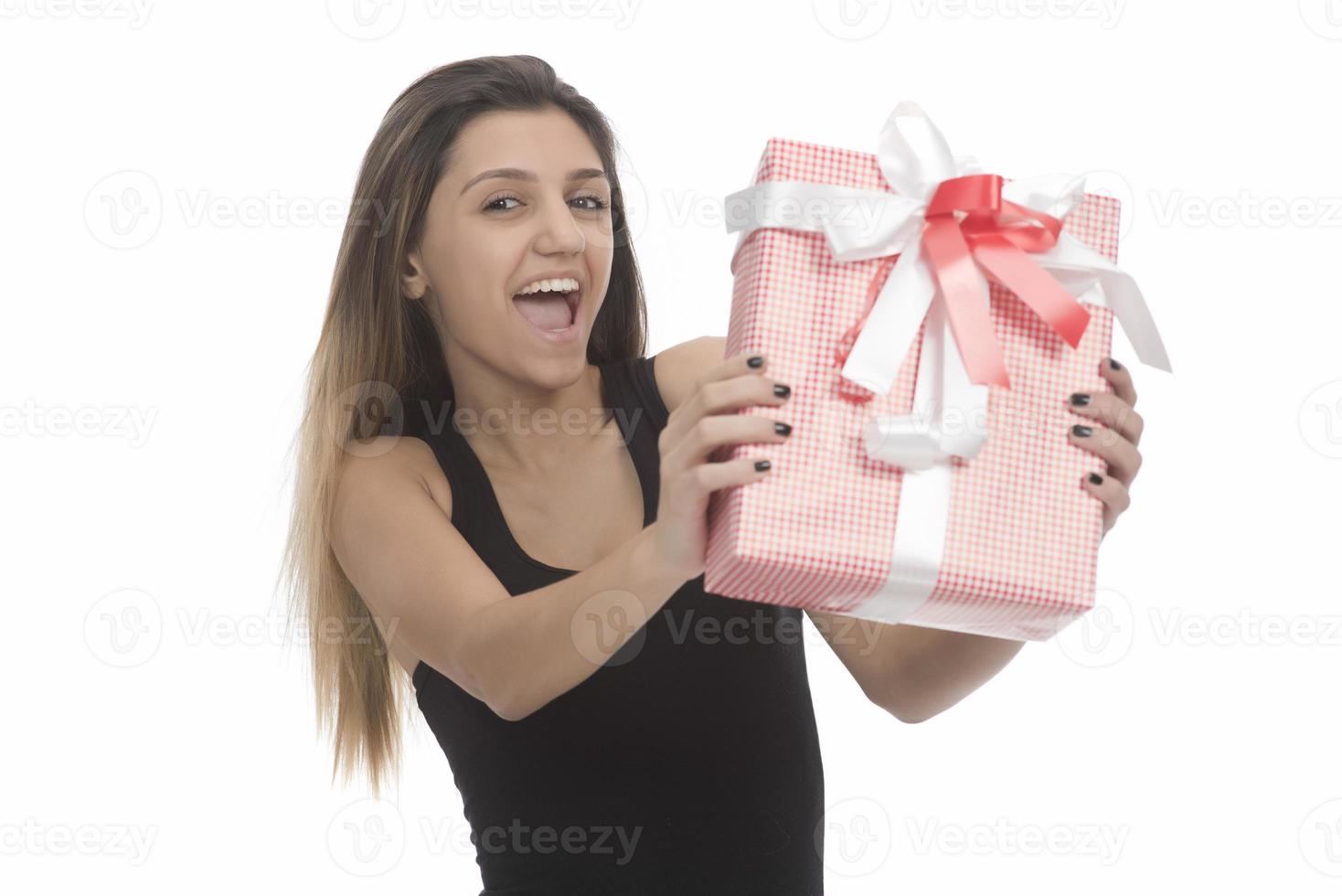 Una mujer hermosa y feliz sonríe y abraza una caja de regalo aislada de fondo blanco foto